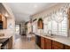 Open kitchen area with wood cabinets, tiled floors, and a view of the living room at 17585 N Coyote Lakes Pkwy, Surprise, AZ 85378