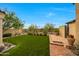 Beautiful backyard with lush green lawn, desert landscaping, and brick pavers leading to a private retreat at 19054 N 97Th Pl, Scottsdale, AZ 85255