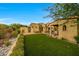 Expansive backyard featuring green lawn, desert landscaping, and a private pool area with lounge chairs and umbrellas at 19054 N 97Th Pl, Scottsdale, AZ 85255
