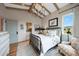 Cozy bedroom with wood-beamed ceiling, iron bed frame, and ensuite bathroom at 19054 N 97Th Pl, Scottsdale, AZ 85255