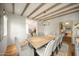 A stylish dining room with wood beams and a rustic table offers a welcoming and elegant atmosphere at 19054 N 97Th Pl, Scottsdale, AZ 85255