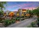 Beautiful stucco house with an arched doorway, desert landscaping, and terracotta roof at 19054 N 97Th Pl, Scottsdale, AZ 85255