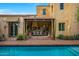 Beautiful exterior of a luxury home showcasing a private pool, covered patio with outdoor dining, and lush landscaping at 19054 N 97Th Pl, Scottsdale, AZ 85255