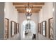 Elegant hallway with exposed wood beams, decorative lighting, and artwork leading to an open dining area at 19054 N 97Th Pl, Scottsdale, AZ 85255