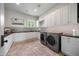 Spacious laundry room with brick floors, tiled backsplash, and modern appliances at 19054 N 97Th Pl, Scottsdale, AZ 85255