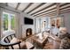 Cozy living room with wooden beams, fireplace, and plenty of natural light from the large windows at 19054 N 97Th Pl, Scottsdale, AZ 85255
