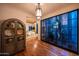 Stylish living room featuring hardwood floors, a decorative cabinet, and desert landscaping views at 19054 N 97Th Pl, Scottsdale, AZ 85255
