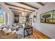 Bright office space featuring custom built-ins, wood beams, modern lighting and a decorative rug at 19054 N 97Th Pl, Scottsdale, AZ 85255