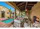 Covered outdoor living space with comfortable seating, a fireplace, and views of the pool and lush landscaping at 19054 N 97Th Pl, Scottsdale, AZ 85255