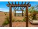 Private outdoor shower area with wood pergola, bench, desert landscaping and brick pavers at 19054 N 97Th Pl, Scottsdale, AZ 85255