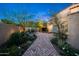 Picturesque brick pathway winding through lush gardens with mature trees and vibrant plants at 19054 N 97Th Pl, Scottsdale, AZ 85255