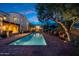 A beautiful pool at dusk with patio furniture and lush landscaping at 19054 N 97Th Pl, Scottsdale, AZ 85255