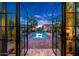 Backyard pool view from inside the home featuring brick patio and lounge seating at 19054 N 97Th Pl, Scottsdale, AZ 85255