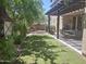 Beautiful backyard featuring a manicured lawn, lush greenery, a covered patio, and privacy fence at 21013 W Wycliff Dr, Buckeye, AZ 85396