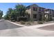 Street view of a two-story home with well-maintained desert landscaping and mature trees at 21013 W Wycliff Dr, Buckeye, AZ 85396