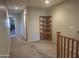 Hallway with neutral walls, carpet, decorative shelving and open doorways to other rooms at 21013 W Wycliff Dr, Buckeye, AZ 85396