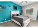 Bright bedroom with a blue accent wall and a queen bed with drawers at 21275 E Russet Rd, Queen Creek, AZ 85142