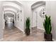 Elegant hallway with arched doorways, neutral paint, travertine flooring, and stylish decor at 21275 E Russet Rd, Queen Creek, AZ 85142
