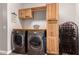 Spacious laundry room features modern appliances and wood cabinetry at 21275 E Russet Rd, Queen Creek, AZ 85142