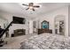 Spacious main bedroom features mounted TV, a ceiling fan, and doorway to bath and walk-in closet at 21275 E Russet Rd, Queen Creek, AZ 85142