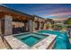 Beautiful pool and spa with outdoor kitchen, bar, and accent lighting, perfect for entertaining at 21275 E Russet Rd, Queen Creek, AZ 85142