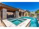 Beautiful pool and spa, covered bar area, and outdoor kitchen make this backyard ideal for entertaining at 21275 E Russet Rd, Queen Creek, AZ 85142