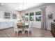 Cozy dining area with a wood table, white chairs, a chandelier, and windows overlooking the backyard at 3118 E Gary Way, Phoenix, AZ 85042