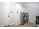 Laundry room features a washer, dryer, sleek white cabinets, tile floor, and a door to the garage at 3118 E Gary Way, Phoenix, AZ 85042