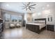 Serene primary bedroom with a king-size bed, a ceiling fan, plantation shutters, and wood-look tile flooring at 3118 E Gary Way, Phoenix, AZ 85042