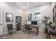 Office with a wooden desk, two computer monitors, rolling desk chair, decorative shelving, and two large windows at 3118 E Gary Way, Phoenix, AZ 85042