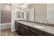 Double sink vanity, granite counters and wood cabinets. Mirror reflects shower and bath at 31409 N 58Th Pl, Cave Creek, AZ 85331