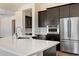 Modern kitchen featuring stainless steel appliances, quartz countertops and dark cabinets at 31409 N 58Th Pl, Cave Creek, AZ 85331