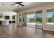 Open-concept living room with wood-look tile floors leading to the kitchen and outdoor pool area at 31409 N 58Th Pl, Cave Creek, AZ 85331
