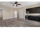 Spacious living room featuring modern wood floors, ceiling fan, and a convenient wet bar area at 31409 N 58Th Pl, Cave Creek, AZ 85331