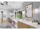 Luxurious bathroom with a freestanding tub, double vanities, and a view of lush greenery at 325 W Solano Dr, Phoenix, AZ 85013