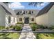 Inviting front entrance with a modern glass-framed door, complemented by lush landscaping and stylish exterior lighting at 325 W Solano Dr, Phoenix, AZ 85013
