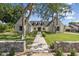 Elegant home exterior featuring lush green lawn, mature shade trees, and a welcoming walkway leading to the entrance at 325 W Solano Dr, Phoenix, AZ 85013