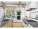 Modern kitchen boasting stainless steel appliances, black countertops, an island, and a window view at 325 W Solano Dr, Phoenix, AZ 85013