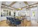 Open kitchen with an island, bar seating, wood-beamed ceiling, and stainless steel appliances at 325 W Solano Dr, Phoenix, AZ 85013