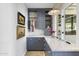 Contemporary laundry room features custom blue cabinets, marble counters and tiled walls at 325 W Solano Dr, Phoenix, AZ 85013
