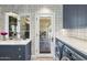 Modern laundry room features white tiled wall, marble counter and view of outdoor patio at 325 W Solano Dr, Phoenix, AZ 85013