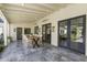 Elegant covered patio boasts ample seating, dark-framed windows, and stylish tile flooring at 325 W Solano Dr, Phoenix, AZ 85013