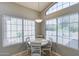 Sunlit dining area with a round table, four chairs, and large windows with blinds at 363 W Bruce Ave, Gilbert, AZ 85233