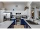 Well-lit kitchen features stainless steel appliances, blue bottom cabinets and white top cabinets at 363 W Bruce Ave, Gilbert, AZ 85233