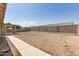 Large backyard with rock landscaping, a covered patio, and a tall block fence at 3646 E Rousay Dr, San Tan Valley, AZ 85140