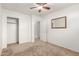 Carpeted bedroom with standard closet, ceiling fan, and a simple mirror at 3646 E Rousay Dr, San Tan Valley, AZ 85140