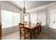 Cozy dining area featuring a wooden table set, large windows with blinds, and a charming chandelier at 3646 E Rousay Dr, San Tan Valley, AZ 85140