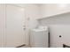 Bright laundry room with washing machine, a door leading outside, and overhead shelving at 3646 E Rousay Dr, San Tan Valley, AZ 85140