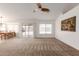 Bright living area featuring neutral carpet, ceiling fan, adjacent dining area, and backyard access at 3646 E Rousay Dr, San Tan Valley, AZ 85140