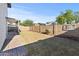 A backyard with a grass lawn, block wall, and a view of some mature landscaping at 3651 W Escuda Dr, Glendale, AZ 85308
